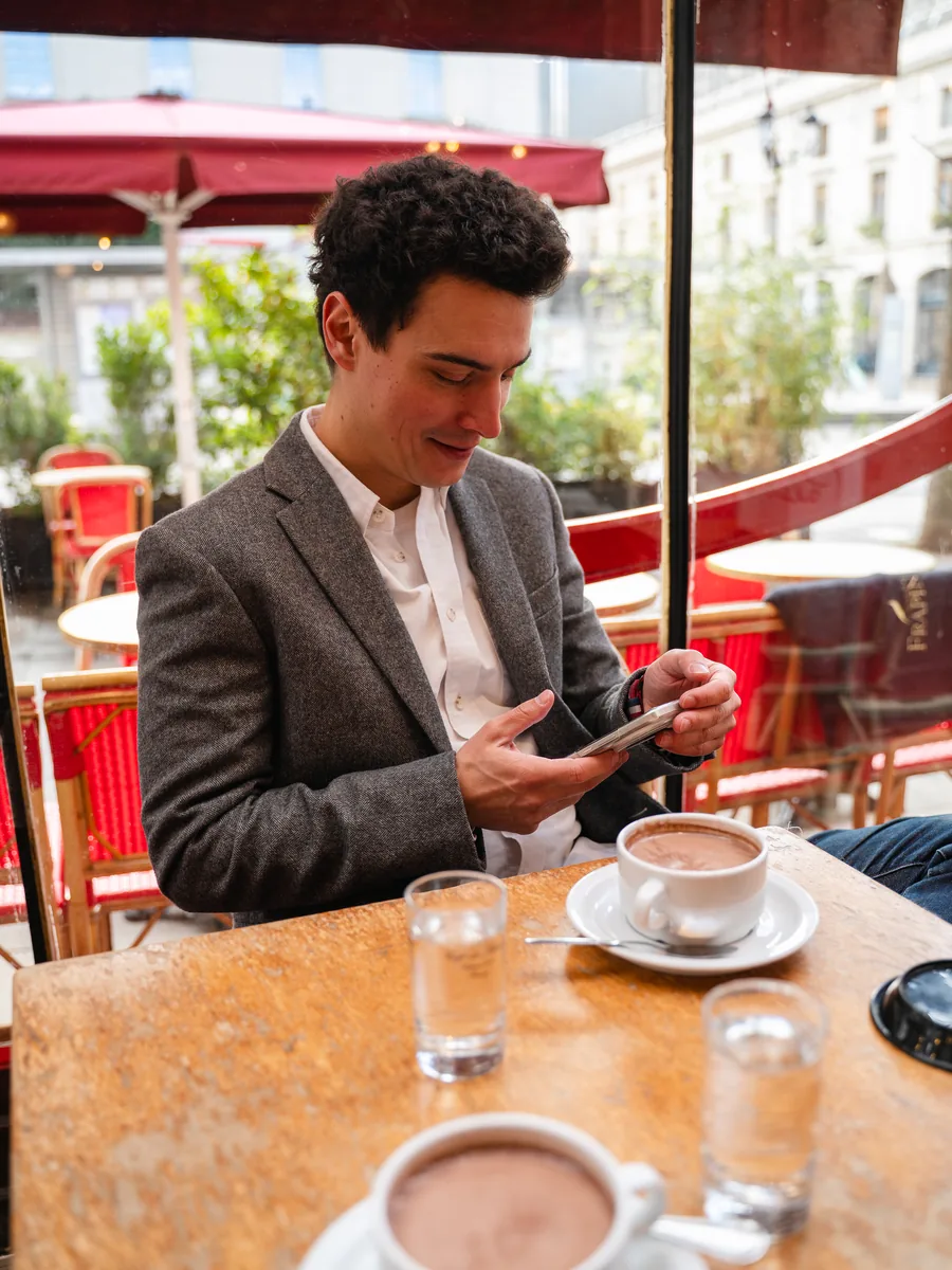 Alexis Attimont en terrasse de café, deux chocolats chauds sur la table